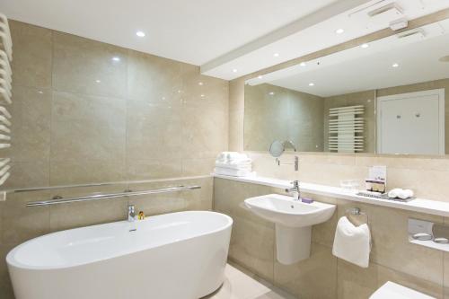 The Stormont Hotel في بلفاست: حمام مع حوض أبيض ومغسلة