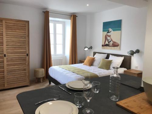 a bedroom with a bed and a table with plates on it at Centre Ville Location in La Rochelle