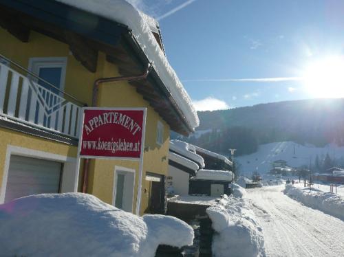 a building covered in snow with a sign on it at Appartement Königslehen in Radstadt