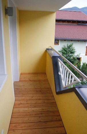 a balcony with a wooden floor and a railing at Appartement Königslehen in Radstadt