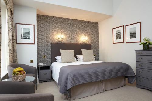 a bedroom with a large bed and two chairs at The Royal Hotel in Ventnor