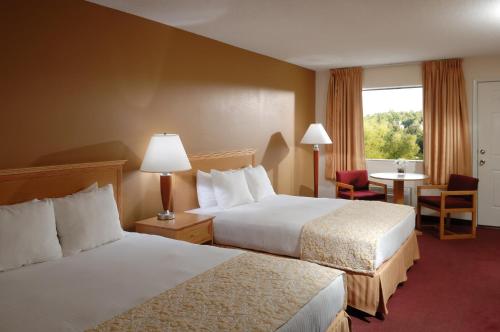 Habitación de hotel con 2 camas y ventana en Whispering Hills Inn, en Branson