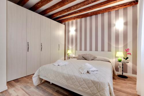 una camera con un grande letto e armadi bianchi di Ca' della Darsena - Arsenale a Venezia