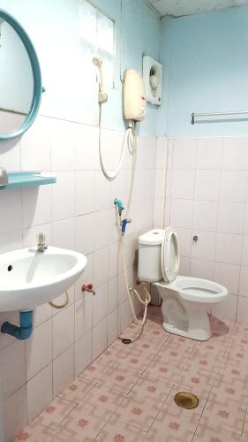 a bathroom with a toilet and a sink at Montra Guesthouse in Ranong