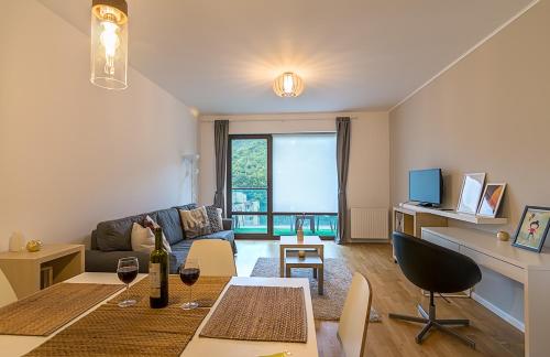 a living room with a couch and a table at Tampa Gardens - Mountain View Apartment in Braşov