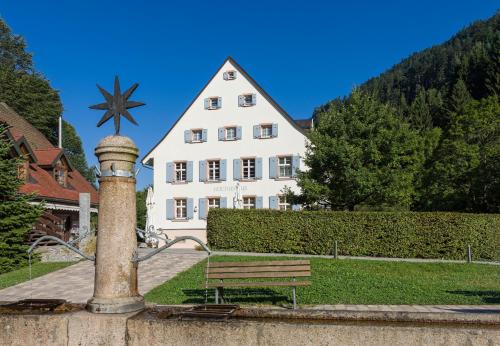 a building with a fountain in front of a bench at Hotel Hofgut Sternen - Ravennaschlucht in Breitnau