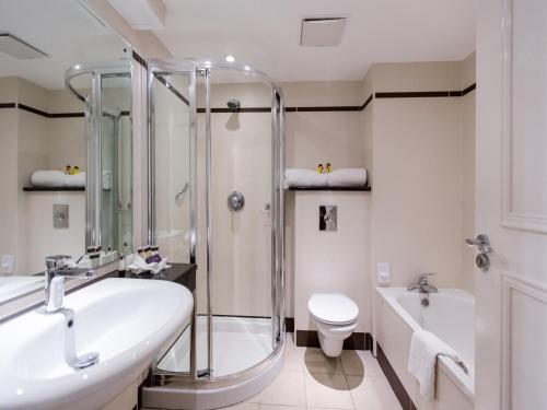 a bathroom with a shower and a sink and a toilet at Everglades Hotel in Derry Londonderry