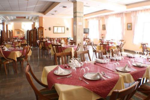 uma sala de jantar com mesas e cadeiras com toalha de mesa vermelha em Escudo de Granada em Puerto-López