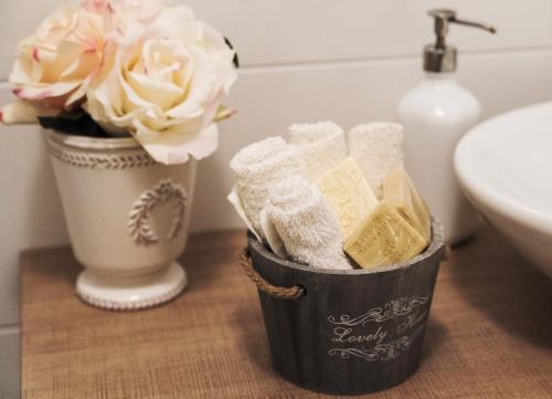 een badkamer met een mand zeep en een vaas met bloemen bij GiaVa Apartment in Baronissi