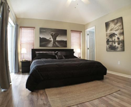 a bedroom with a large black bed in a room with windows at Villa Dunes Court in Haines City