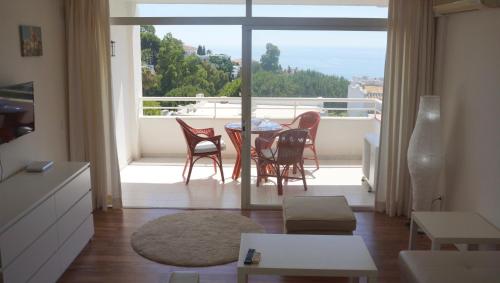 ミハス・コスタにあるSea view apartment in Mirafloresのリビングルーム(テーブル、椅子付)