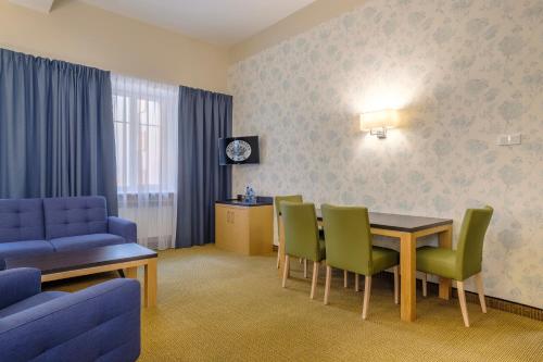 a room with a dining table and chairs and a table and a couch at Hotel Reytan in Warsaw