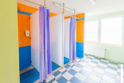 a bathroom with colorful walls and shower curtains at Hostel Brize in Liepāja