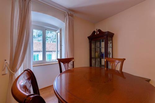 a dining room with a table and chairs and a window at Kotor old town Palace Bucha in Kotor