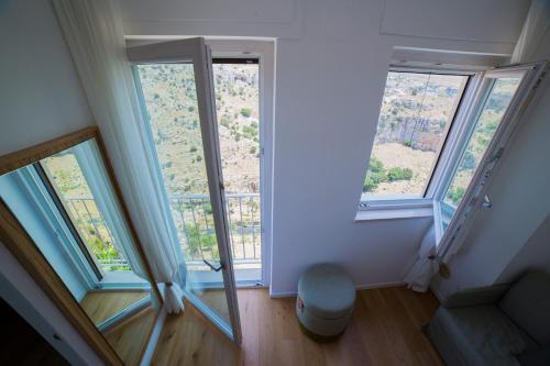 ein Wohnzimmer mit 2 Fenstern und einem Sofa in der Unterkunft Casa Festa Rooms in Matera