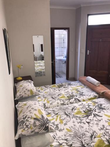ein Schlafzimmer mit 2 Betten und ein Badezimmer mit einem Waschbecken in der Unterkunft Marietjie's Guesthouse in Swakopmund