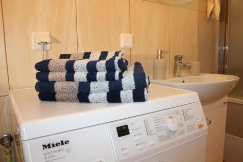 uma máquina de lavar roupa com toalhas em cima na casa de banho em Sunshine Apartament Sopot em Sopot