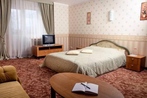 オスタシコフにあるホテル エポスのベッドルーム(ベッド1台、テレビ、テーブル付)