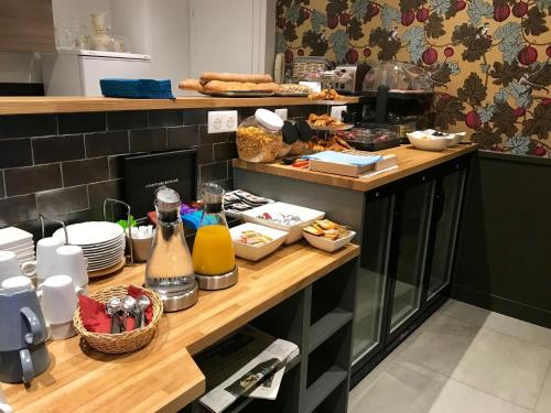 a kitchen with a counter with food on it at Excelsior Batignolles in Paris