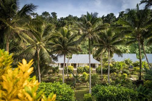 a house in the middle of palm trees at Wellesley Resort Fiji in Vunaniu
