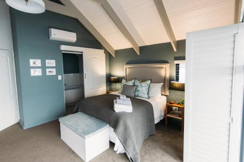 a bedroom with a bed and a blue wall at Linhof Boutique Guest House in Paternoster