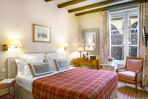 a hotel room with a bed and a chair at Relais Du Louvre in Paris