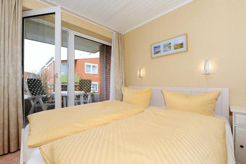 ベンサージールにあるFerienwohnung Schatzinselのベッドルーム1室(ベッド2台付)、バルコニーが備わります。