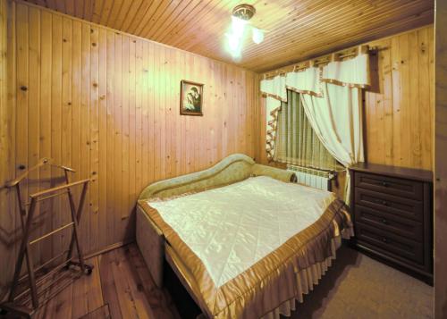 a bedroom with a bed and a wooden wall at Котедж Ватра in Skhidnitsa
