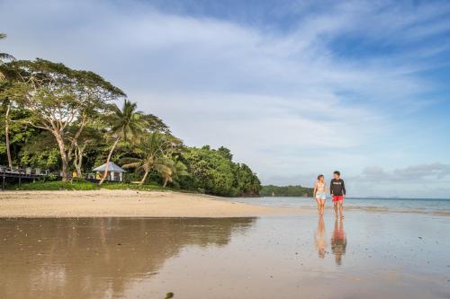 a couple standing on the beach at Wellesley Resort Fiji in Vunaniu