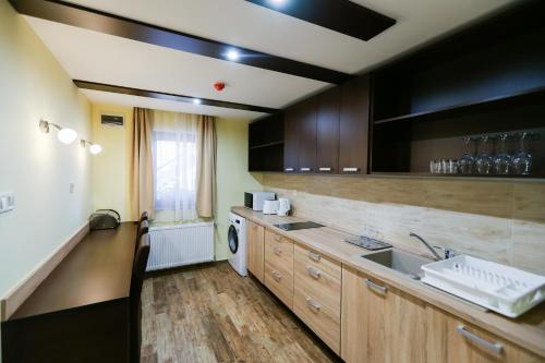 a large kitchen with a sink and a counter at Madison Village in Kisvárda