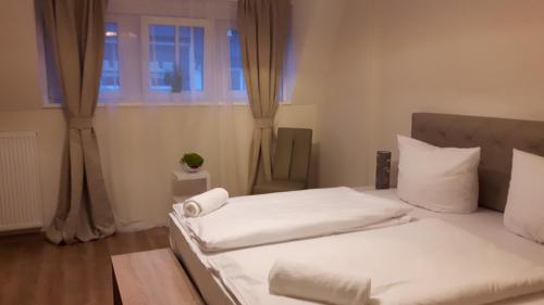 a bedroom with a bed with white sheets and a window at Hotel Ravene in Cochem