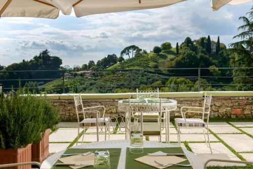 a table and chairs on a patio with a view at Hotel Villa Cipriani in Asolo