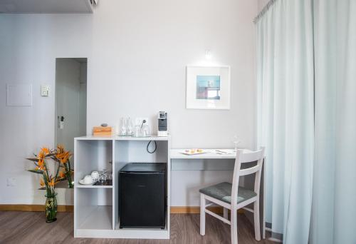 a room with a desk and a table and a chair at Sé Boutique Hotel in Funchal