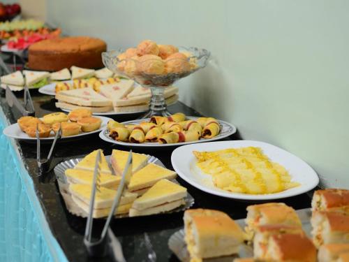 a table filled with different types of food on plates at Hotel Mais in Macapá