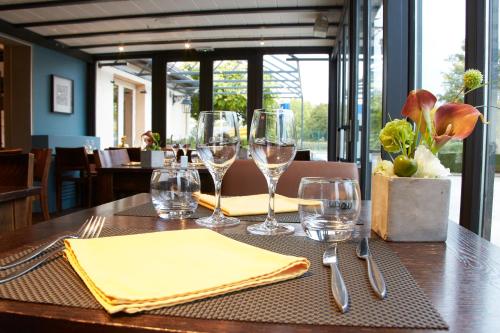 a table with wine glasses and napkins on it at Kyriad Beaune in Beaune