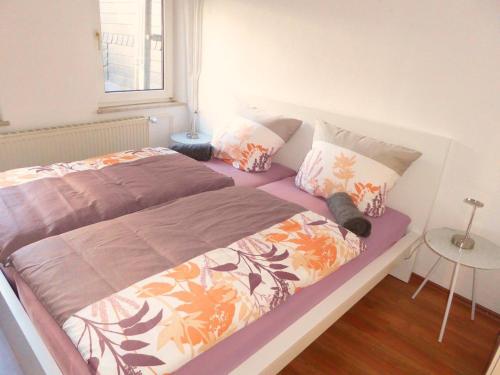 um quarto com uma cama grande com lençóis e almofadas roxos em Camberger Ferienhäuschen em Bad Camberg