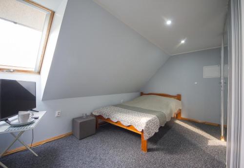 a small bedroom with a bed and a desk at Pensjonat Basia in Dziwnówek
