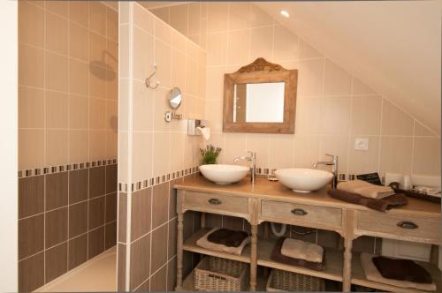 a bathroom with two sinks and a mirror at Le Logis Aux Bulles in Verzy