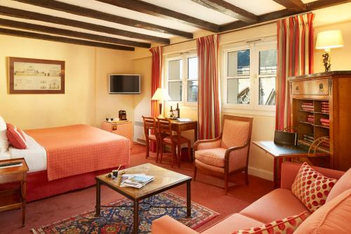 a hotel room with a bed and a living room at Relais Du Louvre in Paris