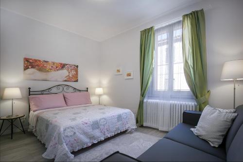 een slaapkamer met een bed, een stoel en een raam bij L'Appartamento del Corso in Santarcangelo di Romagna