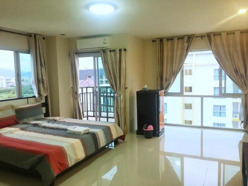 una camera con letto e un balcone con finestre di Sunisa Plus Bangsaen a Bangsaen