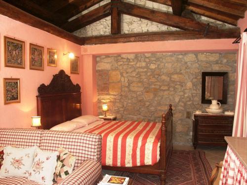 a bedroom with a bed and a stone wall at La Traversina in Stazzano