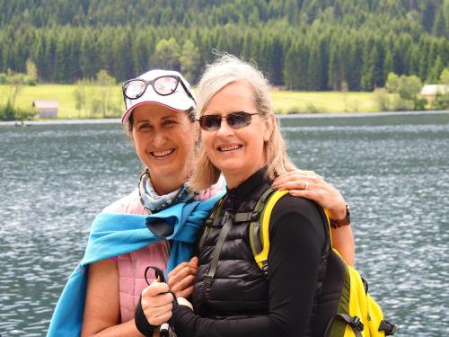 two women are standing next to a body of water at Petra Maria Sölle - Ferienhaus sehr privat in Presseggersee