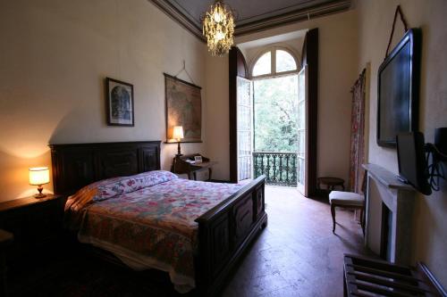 a bedroom with a bed and a large window at Agriturismo Villa Gropella in Valenza
