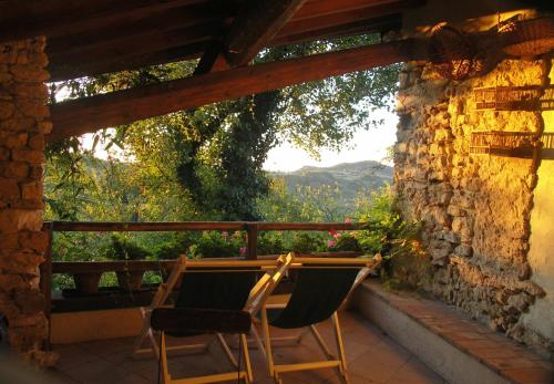 two chairs sitting on a porch with a stone wall at La Traversina in Stazzano