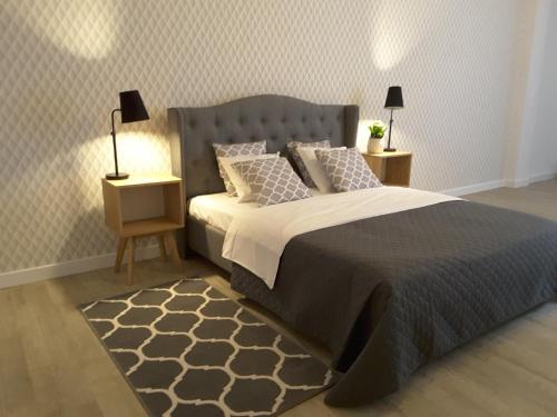 1 dormitorio con 1 cama grande y 2 mesitas de noche en Blooms Inn & Apartments, en Poznan