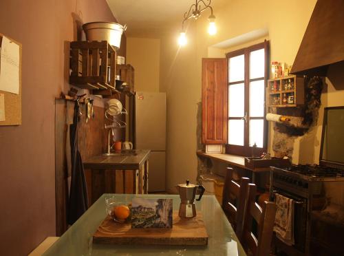 una cucina con tavolo in vetro e piano cottura di Nannai Climbing Home a Ulassai