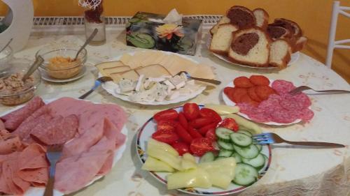 a table topped with plates of different types of food at Zita Haus in Bük