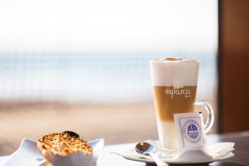 eine Tasse Kaffee und ein Donut auf dem Tisch in der Unterkunft Hostal Alba in La Mata