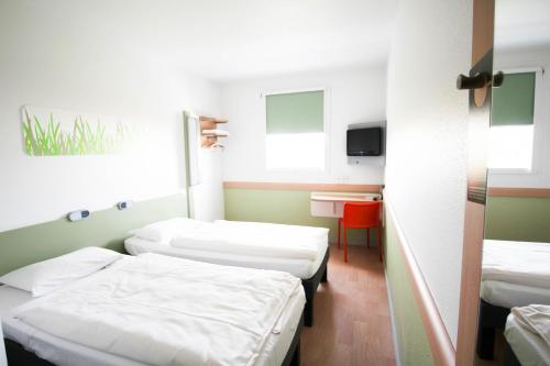 a hospital room with two beds and a table at ibis budget Muenchen Ost Messe in Aschheim